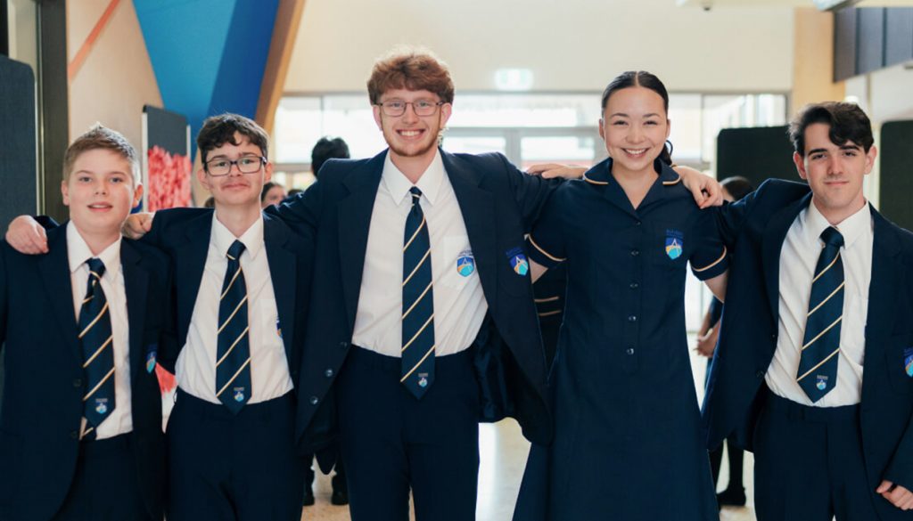 Group of high school students in formal uniforms smiling